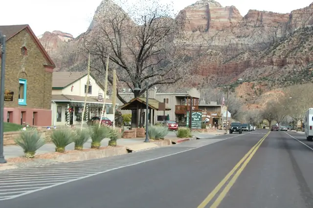 The main street of Springdale, Utah, with red cliffs of Zion National Park behind the town.