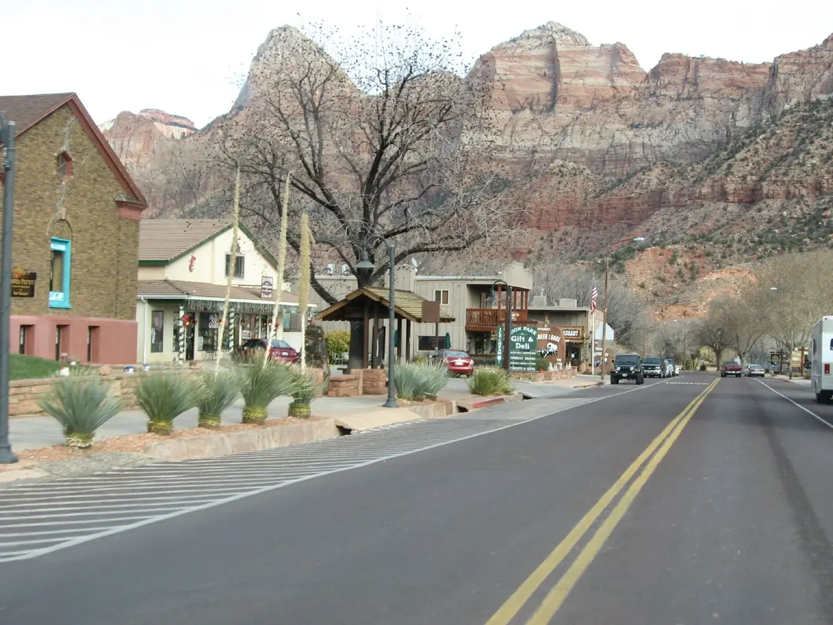 The main street of Springdale, Utah, with red cliffs of Zion National Park behind the town.